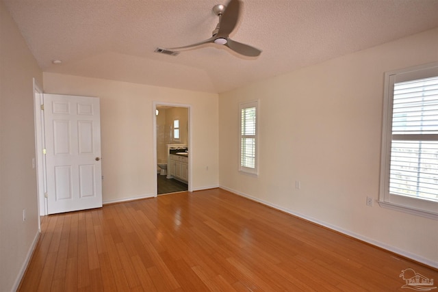 5577 Shadow Shore Pl, Gulf Breeze, FL 32563 - unfurnished bedroom featuring wood-type flooring, a textured ceiling, multiple windows, baseboards, and ensuite bath