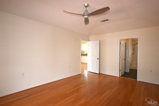 5577 Shadow Shore Pl, Gulf Breeze, FL 32563 - unfurnished bedroom featuring wood finished floors, baseboards, a textured ceiling, ceiling fan, and ensuite bathroom
