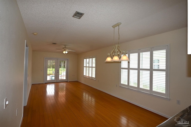 5577 Shadow Shore Pl, Gulf Breeze, FL 32563 - unfurnished room with a ceiling fan, baseboards, hardwood / wood-style floors, a textured ceiling, and a chandelier