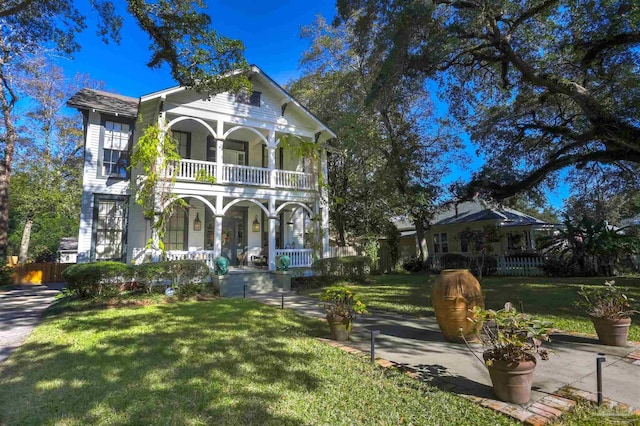 view of front of property featuring a porch, a front yard, and a balcony