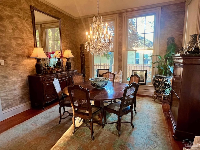 dining area with a notable chandelier, baseboards, and wood finished floors