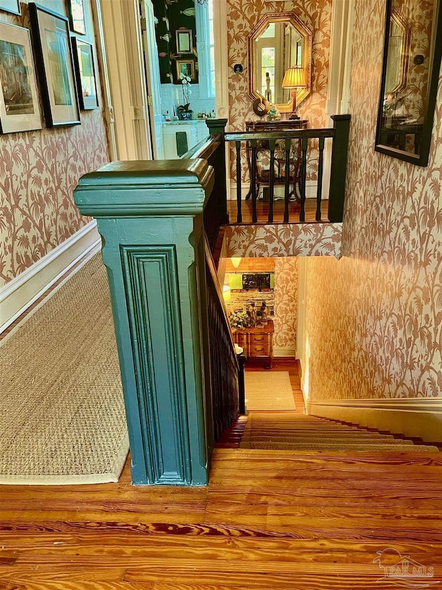interior space with light wood-style floors, baseboards, and wallpapered walls