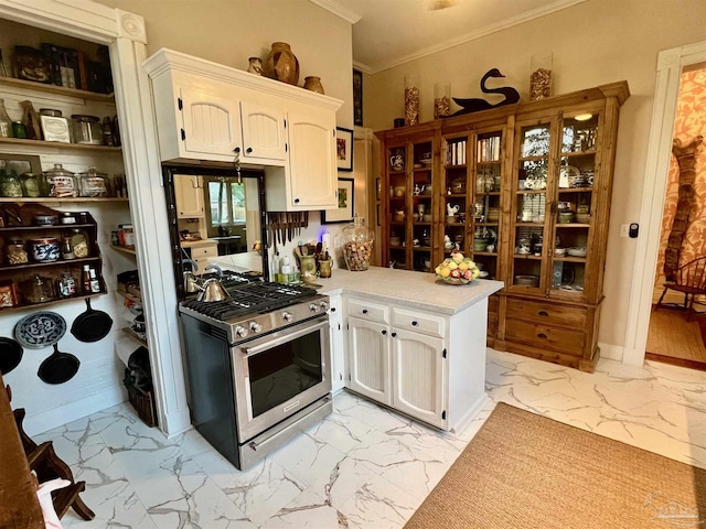 kitchen featuring ornamental molding, marble finish floor, light countertops, stainless steel range with gas cooktop, and white cabinetry