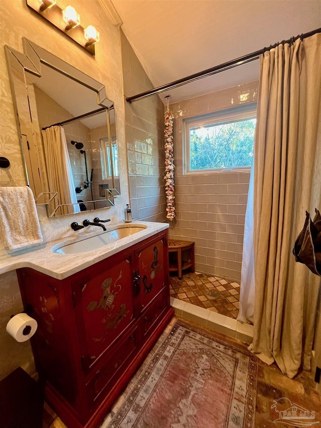 bathroom with a shower stall, vaulted ceiling, and vanity