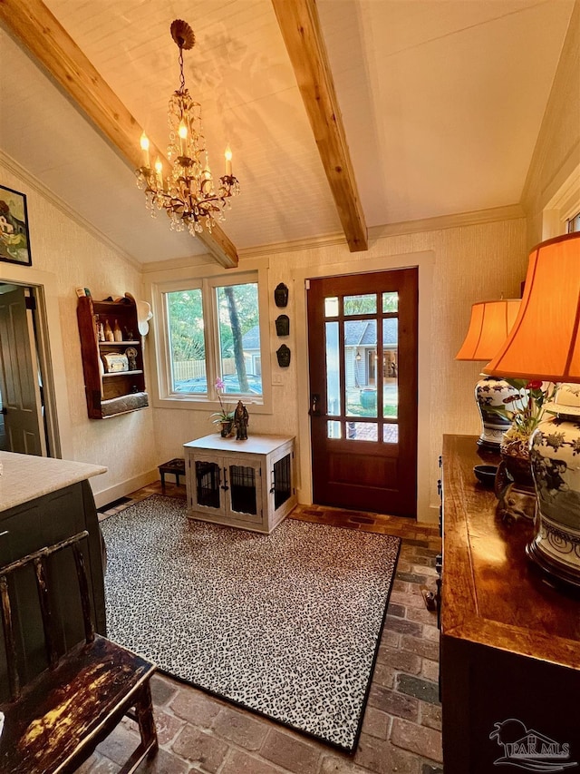foyer entrance featuring lofted ceiling with beams, brick floor, and an inviting chandelier
