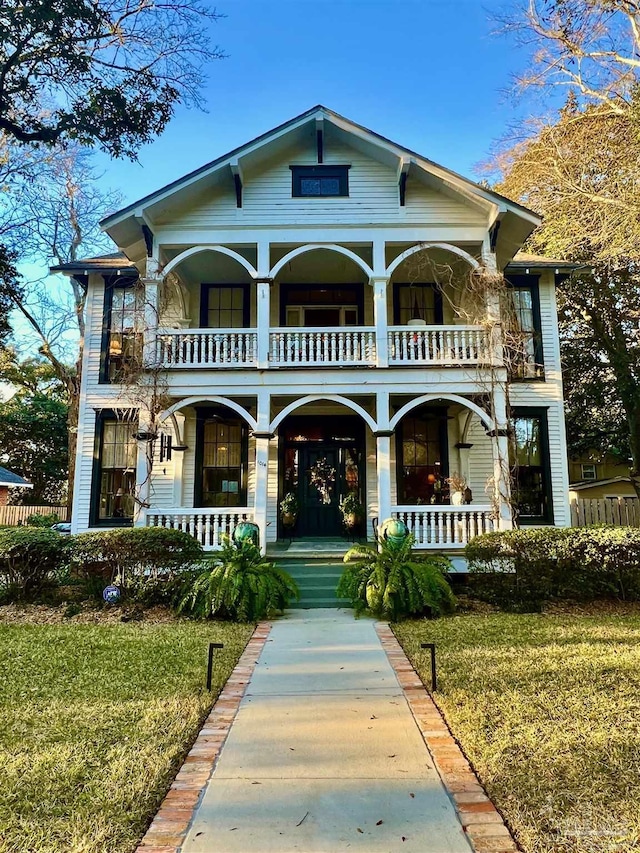 view of front of home featuring a front lawn, a porch, and a balcony