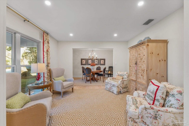 living room with light carpet and an inviting chandelier