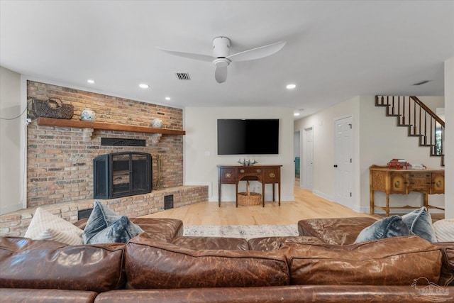 living room featuring ceiling fan and light hardwood / wood-style flooring