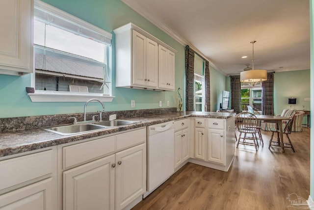 5473 Pensacola Ave, Orange Beach, AL 36561 - kitchen with white dishwasher, a sink, crown molding, light wood-style flooring, and white cabinets