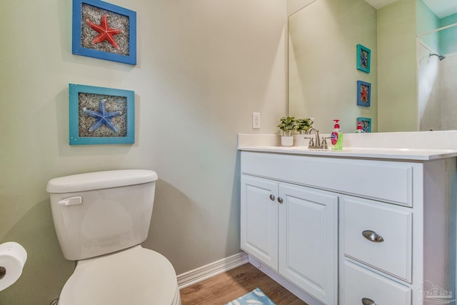 5473 Pensacola Ave, Orange Beach, AL 36561 - bathroom with toilet, vanity, wood finished floors, and baseboards