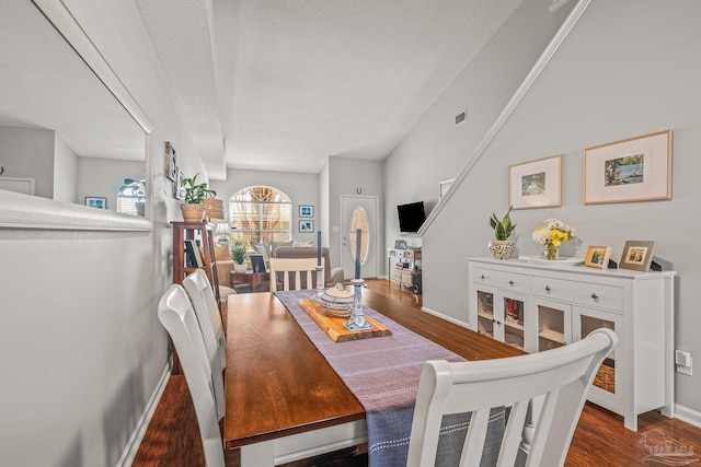 dining room with a textured ceiling and dark hardwood / wood-style floors