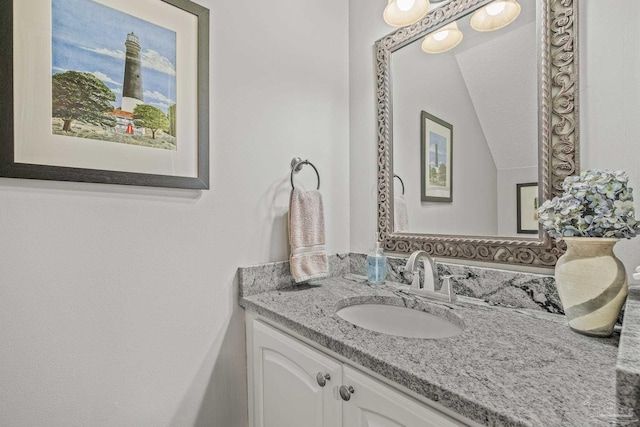 bathroom featuring vanity and lofted ceiling