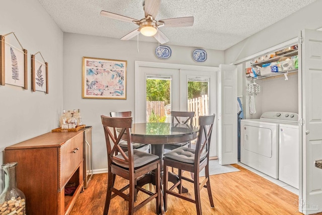 dining area with independent washer and dryer, a textured ceiling, and light wood-type flooring