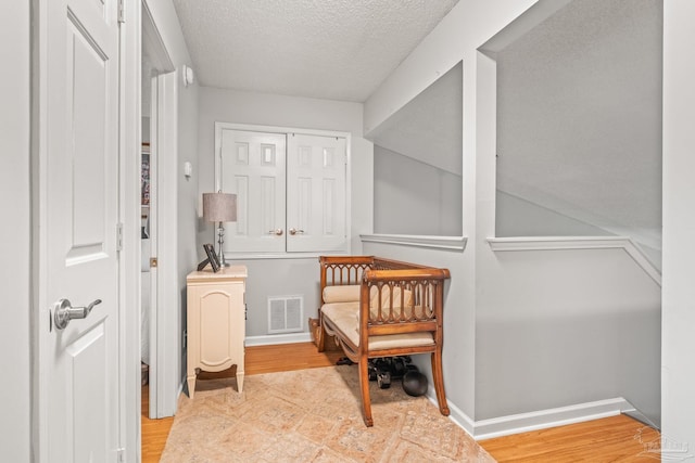 sitting room featuring a textured ceiling and light hardwood / wood-style floors