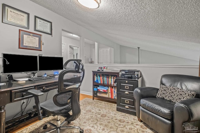 office area featuring lofted ceiling, a textured ceiling, and wood-type flooring