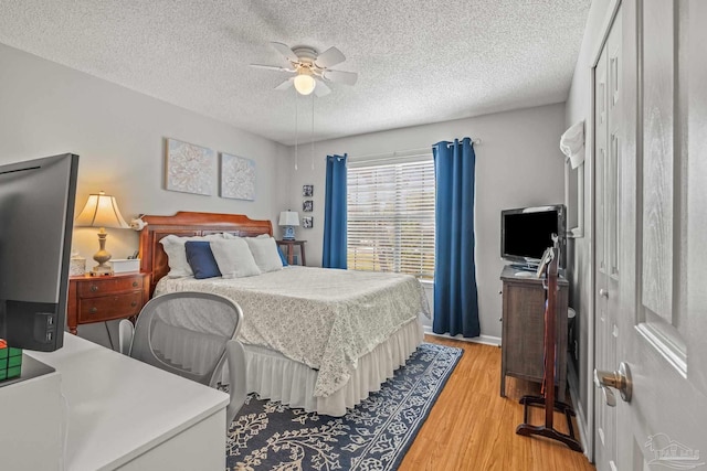 bedroom with light hardwood / wood-style floors, a closet, a textured ceiling, and ceiling fan