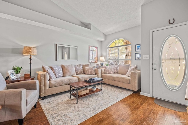 living room featuring hardwood / wood-style floors, a textured ceiling, and vaulted ceiling