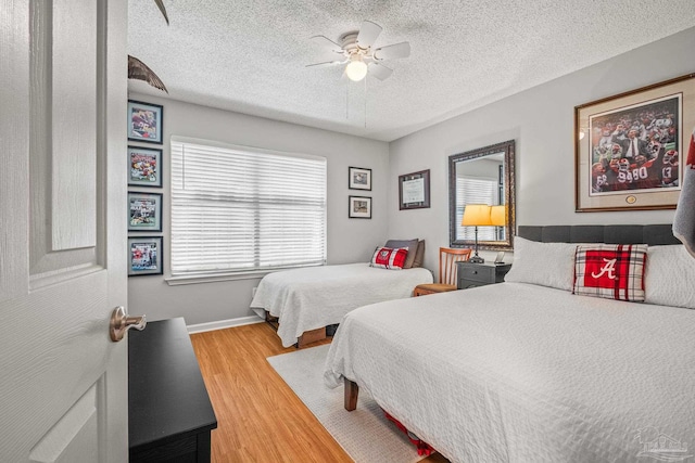 bedroom with hardwood / wood-style floors, a textured ceiling, and ceiling fan