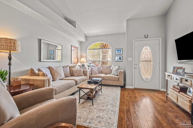 living room featuring dark wood-type flooring, a textured ceiling, and vaulted ceiling