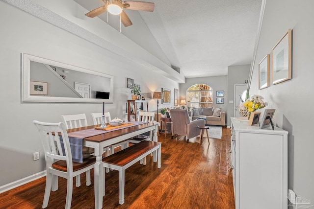 dining room featuring ceiling fan, a textured ceiling, lofted ceiling, and dark hardwood / wood-style flooring