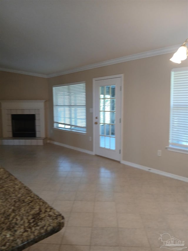 unfurnished living room featuring a fireplace, crown molding, and an inviting chandelier