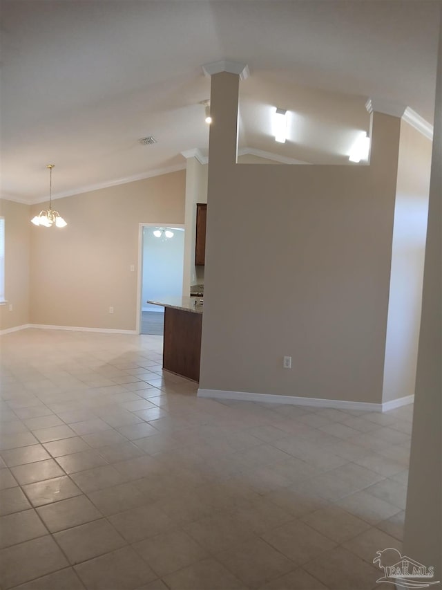 tiled empty room with lofted ceiling, ornamental molding, and a notable chandelier