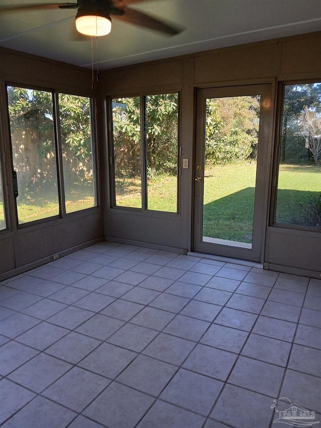 unfurnished sunroom with ceiling fan and a wealth of natural light