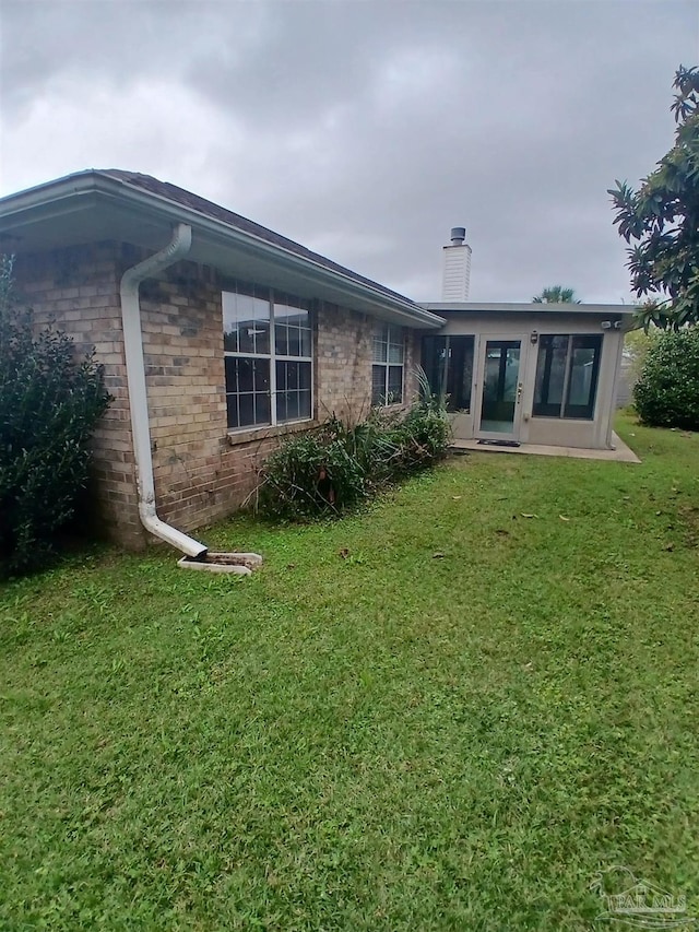 rear view of house featuring a lawn