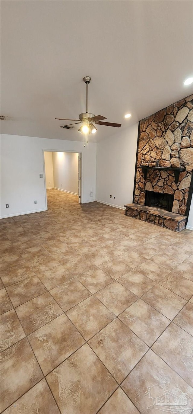 unfurnished living room with ceiling fan and a fireplace