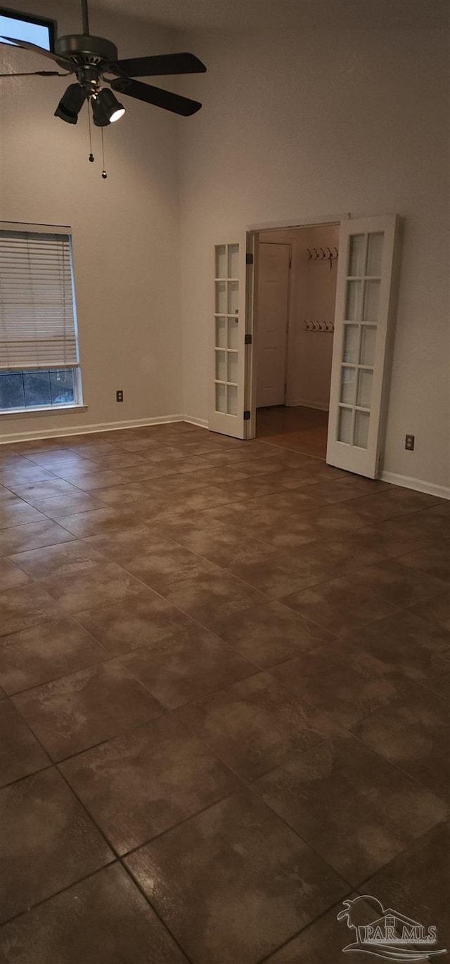 spare room with built in shelves and ceiling fan