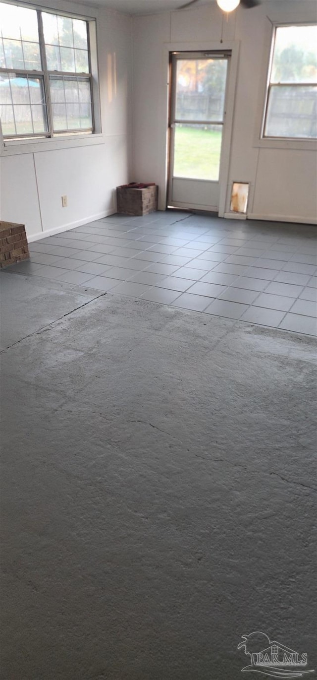 spare room featuring tile patterned flooring and a wealth of natural light