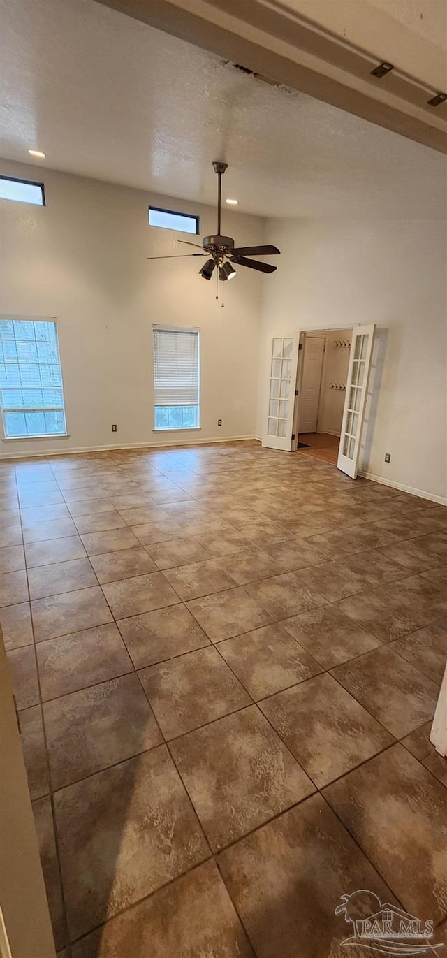 unfurnished living room featuring ceiling fan and a textured ceiling