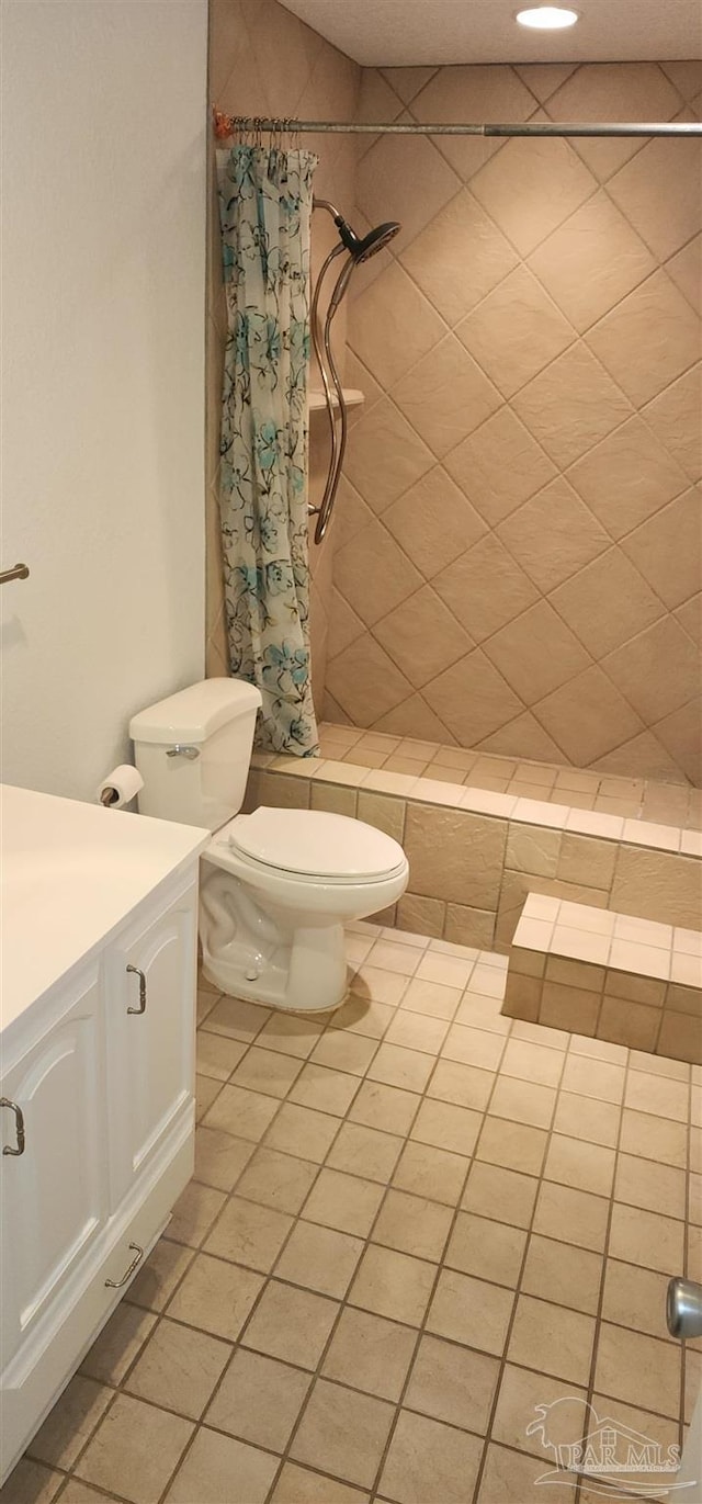 bathroom with vanity, toilet, curtained shower, and tile patterned flooring