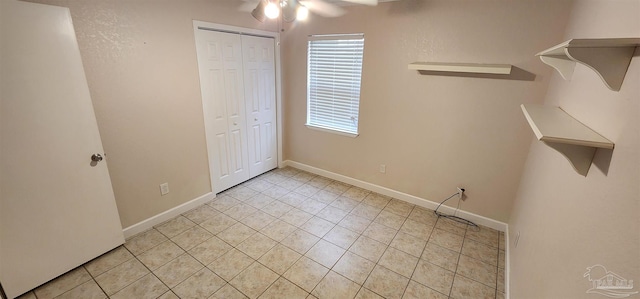 unfurnished bedroom featuring a closet, ceiling fan, and light tile patterned flooring