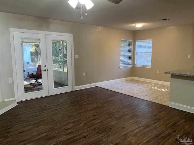 interior space featuring ceiling fan, french doors, hardwood / wood-style floors, and a textured ceiling