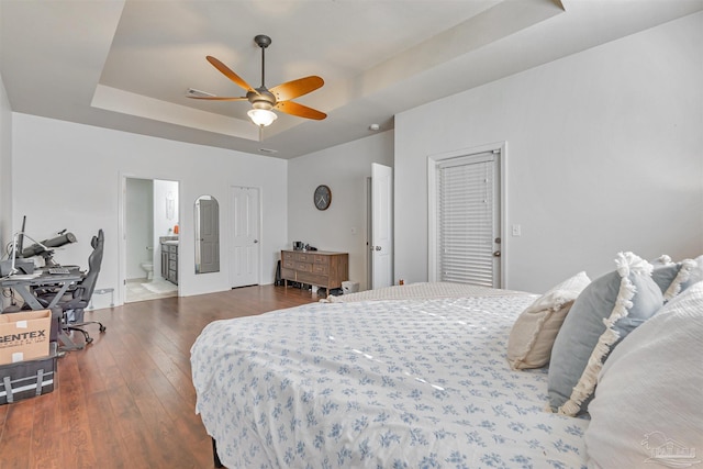 5811 Rustic Ridge Cir, Milton, FL 32570 - bedroom featuring a raised ceiling, wood-type flooring, two closets, connected bathroom, and a ceiling fan