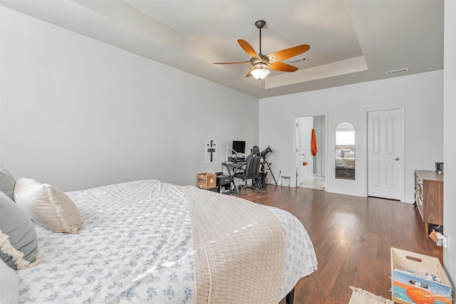 5811 Rustic Ridge Cir, Milton, FL 32570 - bedroom with a tray ceiling, dark wood-style flooring, ceiling fan, a desk, and ensuite bathroom