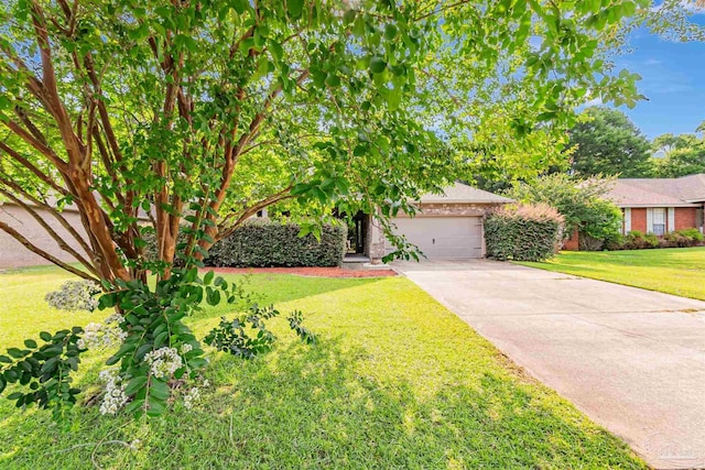 5811 Rustic Ridge Cir, Milton, FL 32570 - obstructed view of property featuring concrete driveway, a garage, a front yard, and brick siding