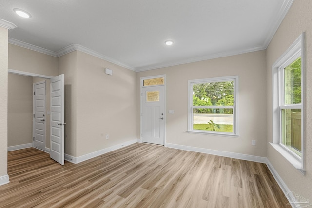 entryway featuring light wood-style floors, a healthy amount of sunlight, and ornamental molding