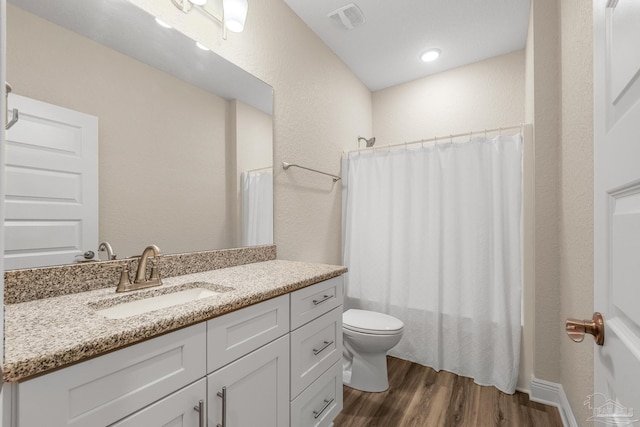 full bathroom with toilet, visible vents, shower / tub combo, wood finished floors, and vanity