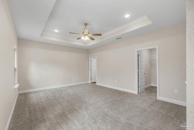 interior space with a raised ceiling, visible vents, recessed lighting, a ceiling fan, and ornamental molding