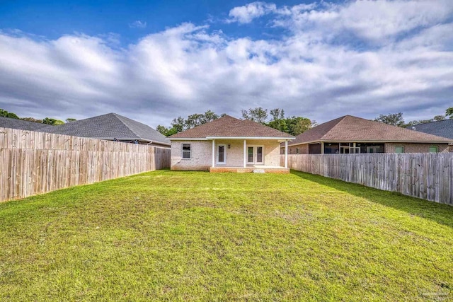 back of house featuring a fenced backyard and a yard