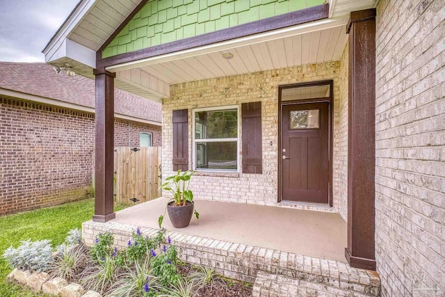 property entrance with a porch and fence
