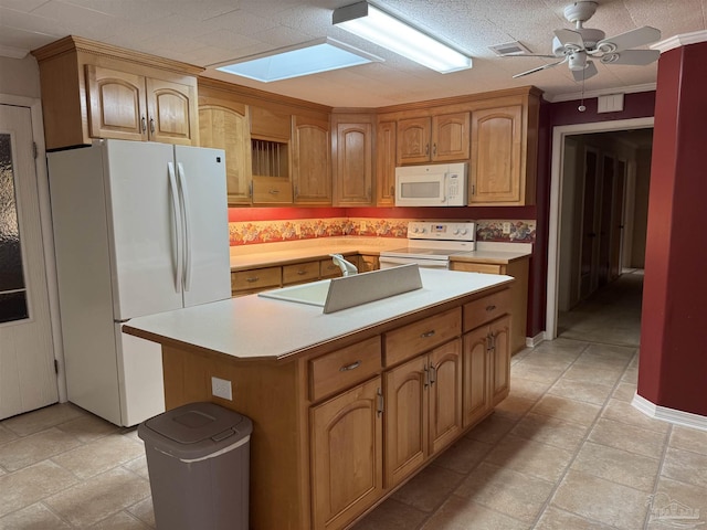 kitchen with crown molding, white appliances, a skylight, and a kitchen island