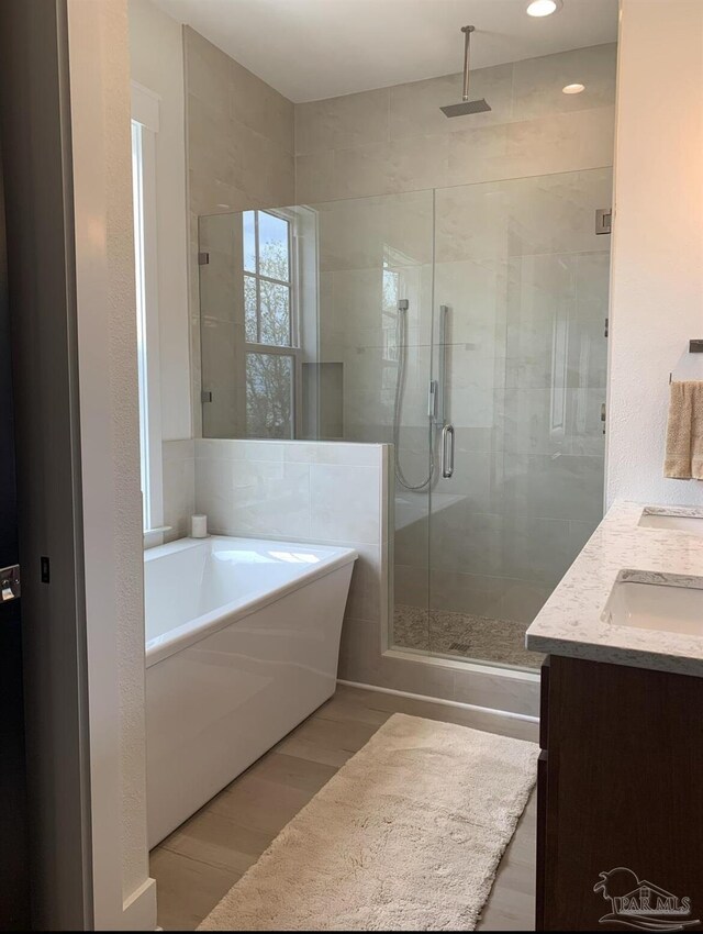 1557 Winding Shore Dr, Gulf Breeze, FL 32563 - full bath with a bathtub, a stall shower, double vanity, wood finished floors, and recessed lighting