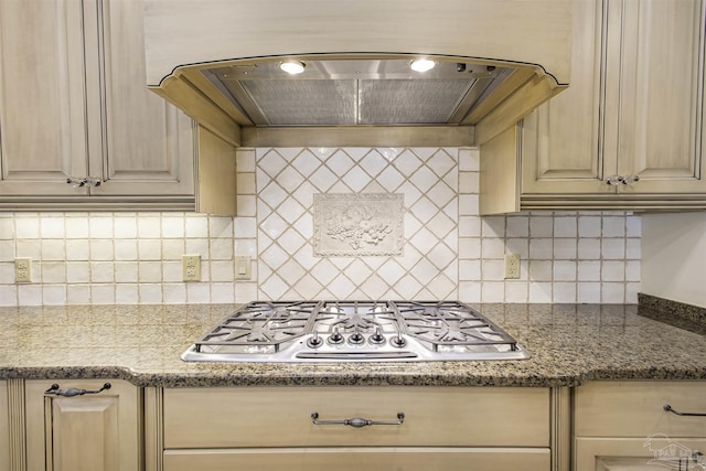 kitchen featuring stainless steel gas stovetop, premium range hood, light brown cabinets, and decorative backsplash