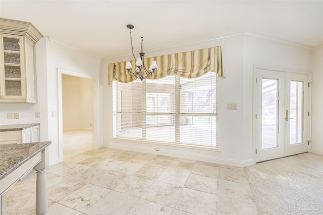 unfurnished dining area featuring ornamental molding, light carpet, a wealth of natural light, and a chandelier