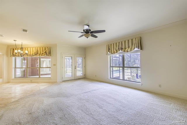 carpeted spare room featuring ceiling fan with notable chandelier, ornamental molding, and french doors