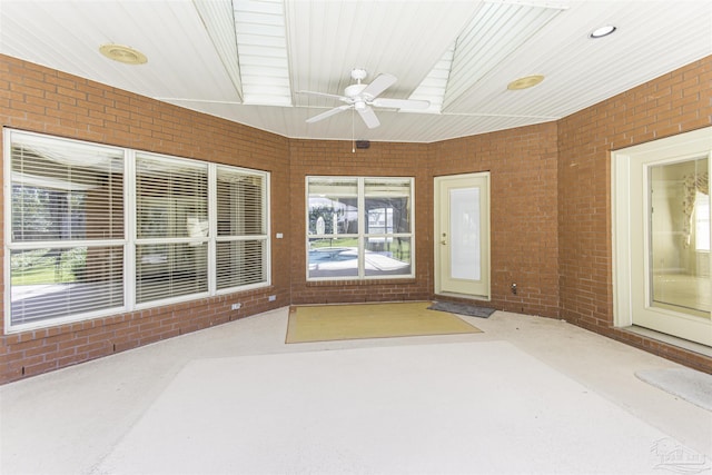 unfurnished sunroom with ceiling fan