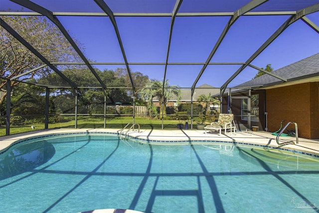 view of swimming pool featuring a patio and glass enclosure